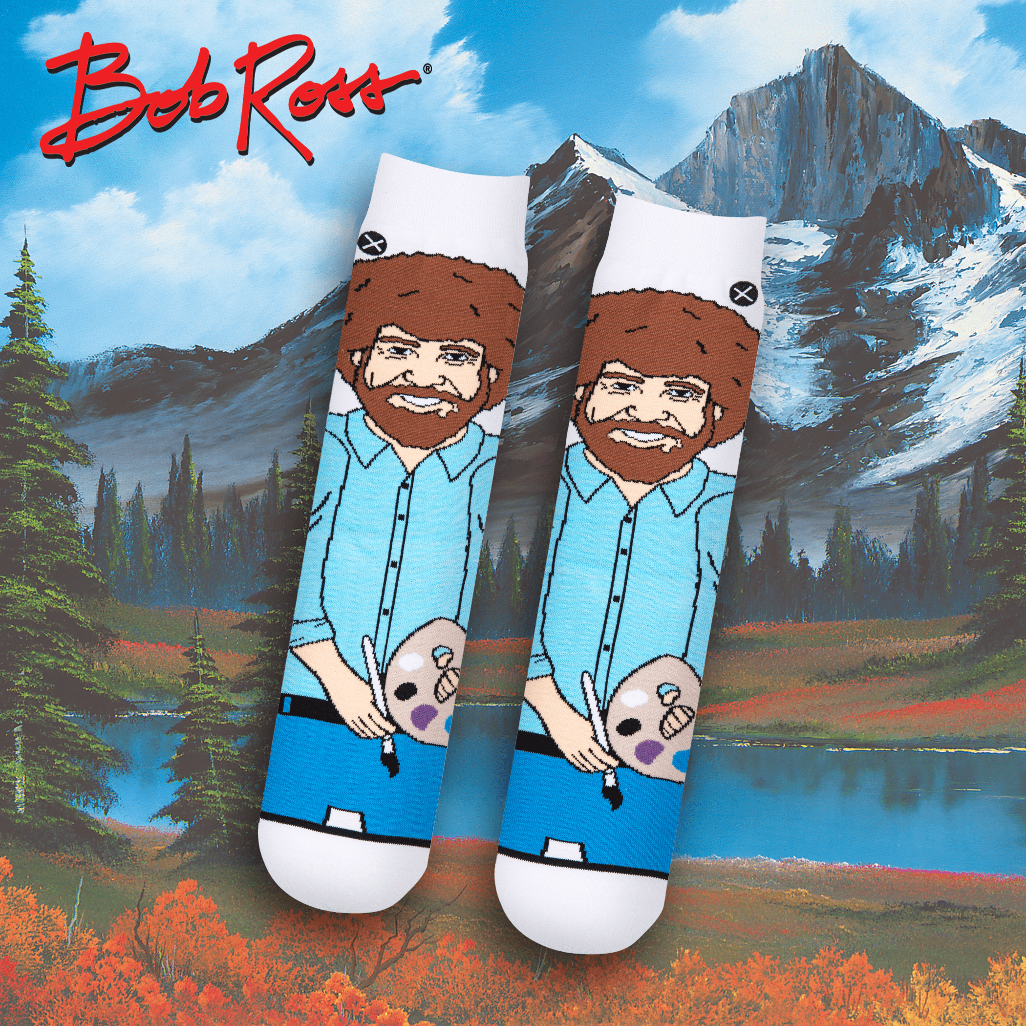 Cozy scene with Bob Ross socks in front of a peaceful mountain landscape, featuring Bob Ross holding a paint palette, perfect for art and nature lovers.
