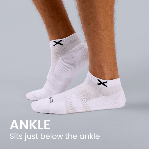 White ankle socks with black X logo, sitting just below the ankle on model feet.