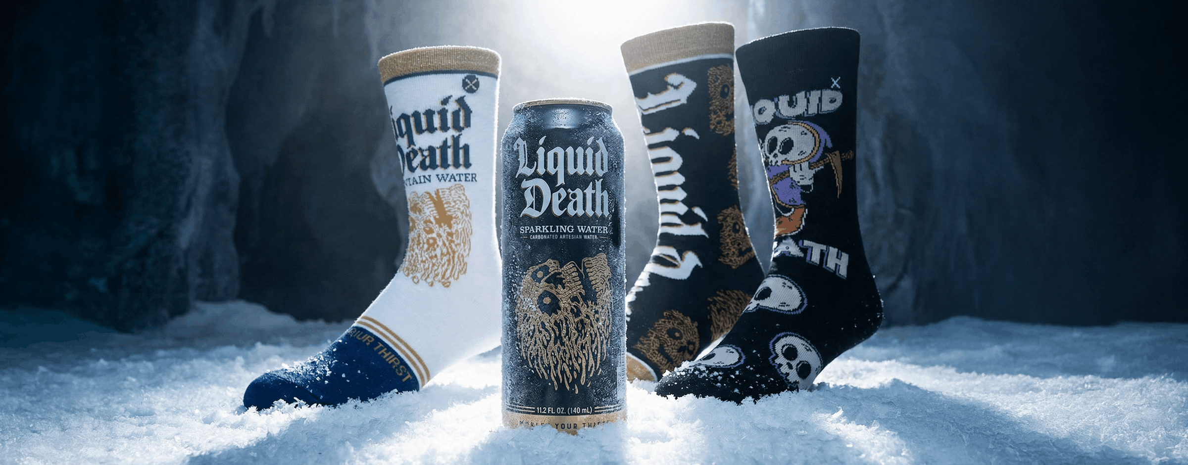 Two cans of 'Liquid Death' beer and a pair of matching socks in the snow.