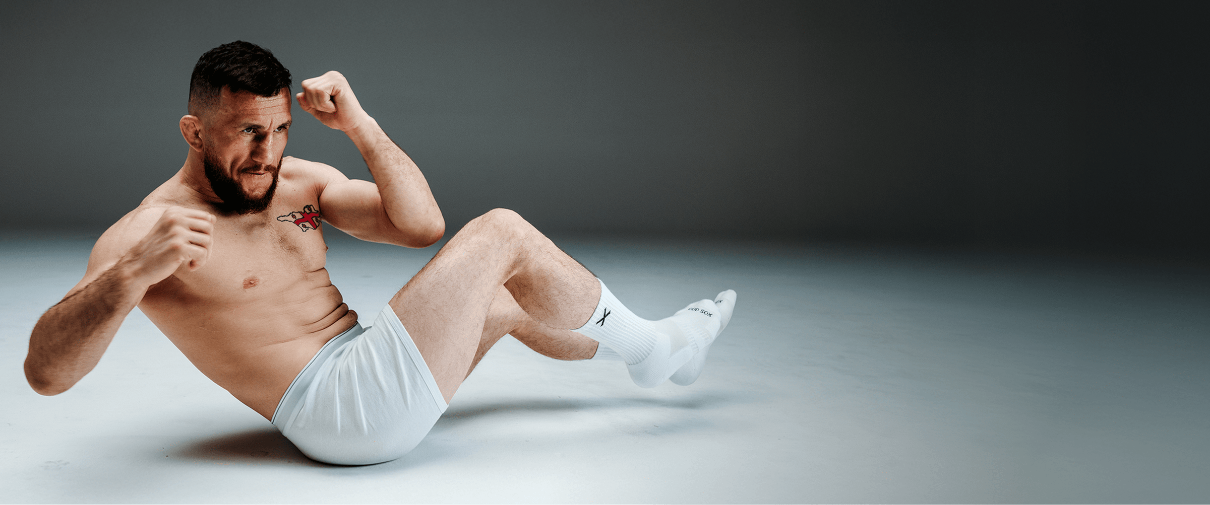 Man in white underwear flexing muscles on a gray background