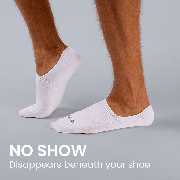 White no show socks with subtle black logo, disappearing beneath shoes on model feet.