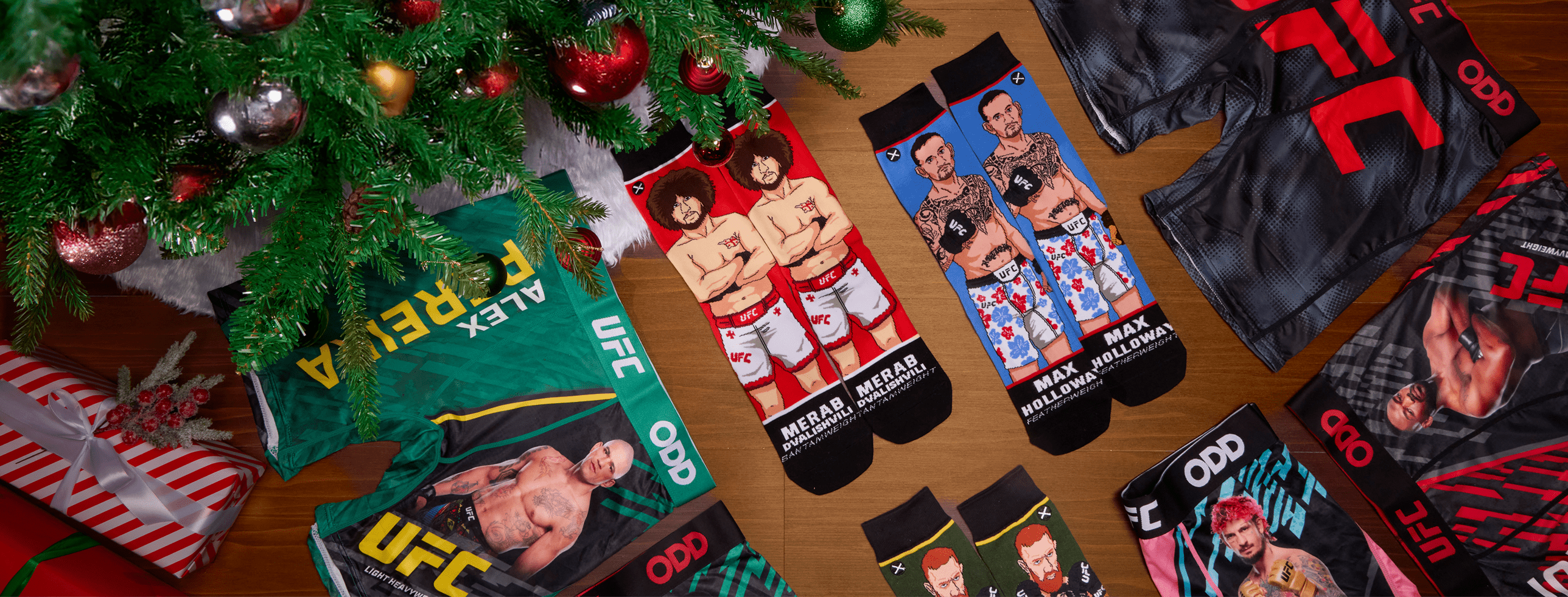 Collection of UFC-themed socks displayed under a Christmas tree with festive decor.