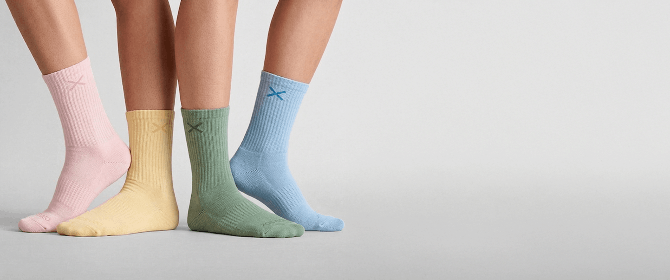 Four pairs of colorful socks on a neutral background