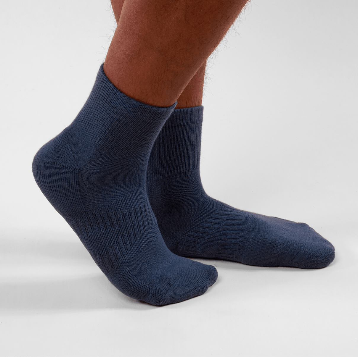 Navy blue socks worn by a person on a light gray background