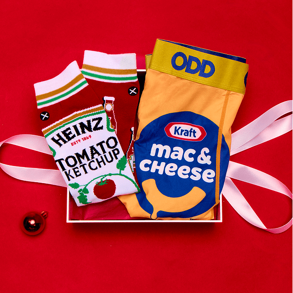 Socks designed to look like Heinz Tomato Ketchup and Kraft Mac & Cheese packages on a red background.