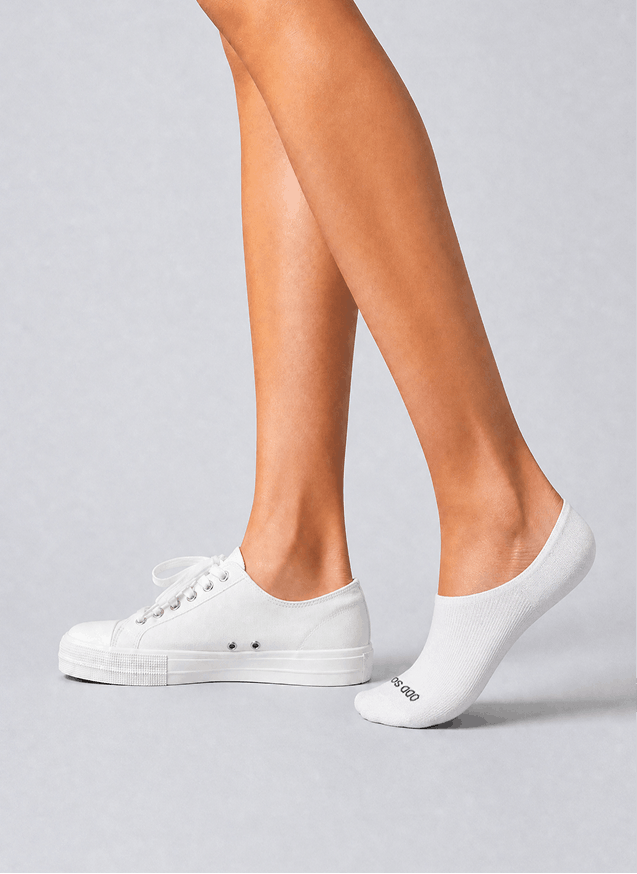 White sneakers and socks on a gray background