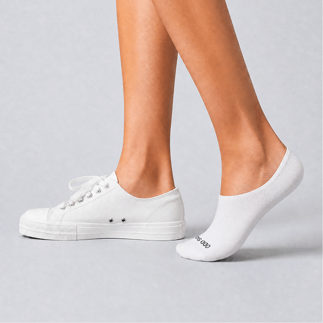White sneakers and socks on a gray background