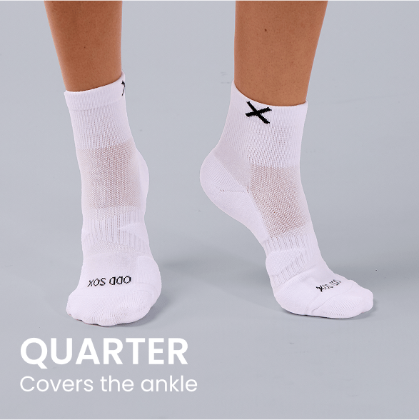 White quarter socks with black X logo, covering the ankle on model feet.